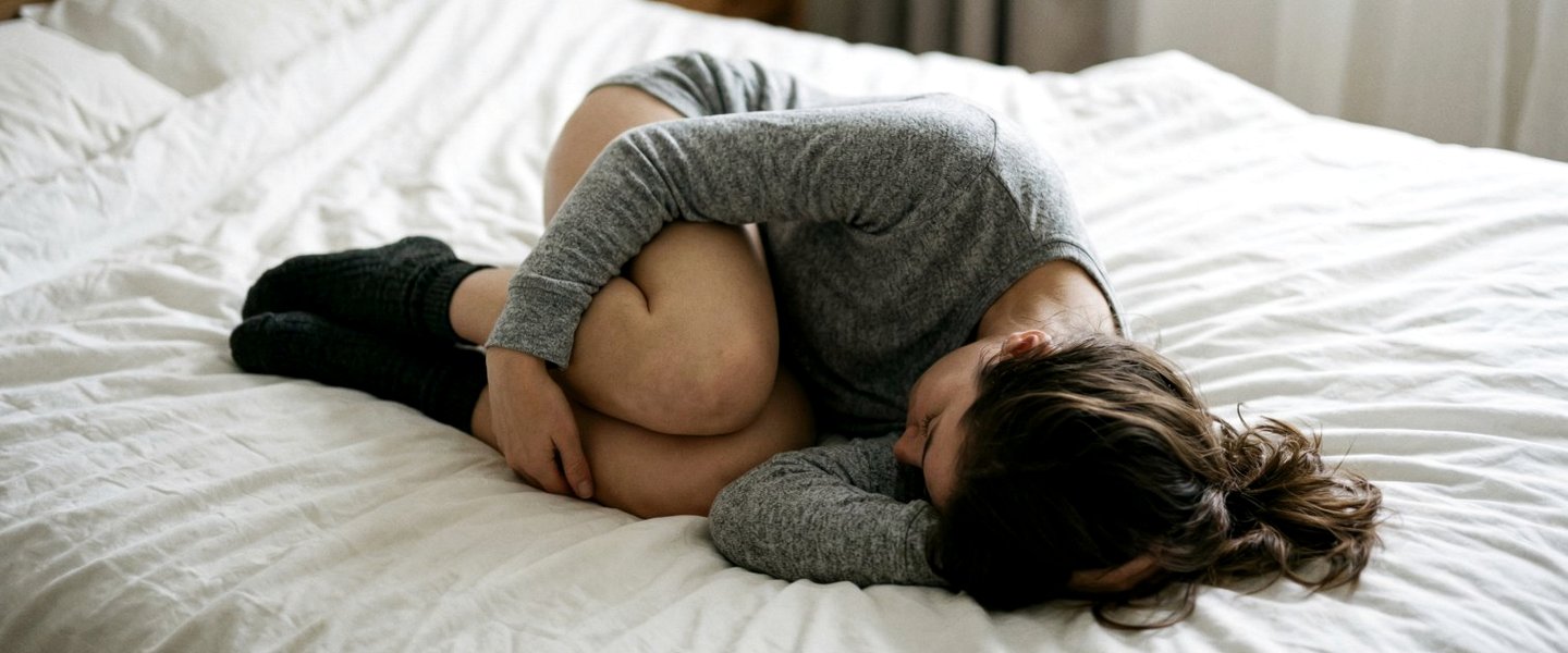 Donna raccolta su se stessa, immagine del dolore pelvico cronico